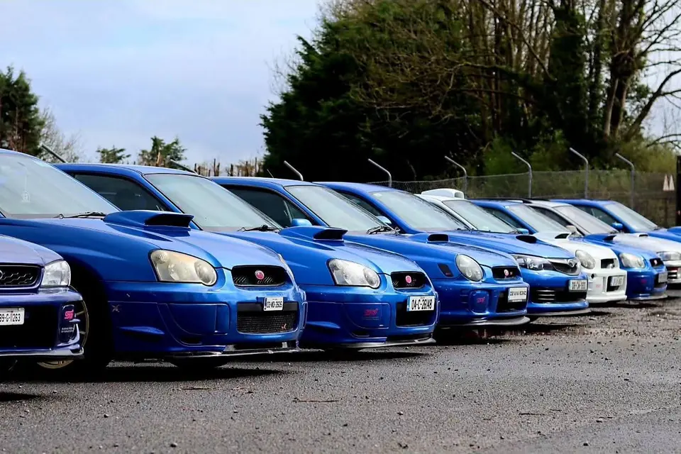 A row of blue Subaru Imprezas at a club meet