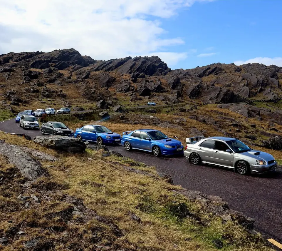 Club cars parked along a winding mountain pass
