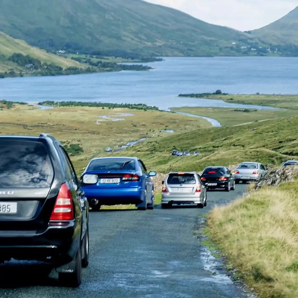 Club cars on a narrow road through Doolough Valley